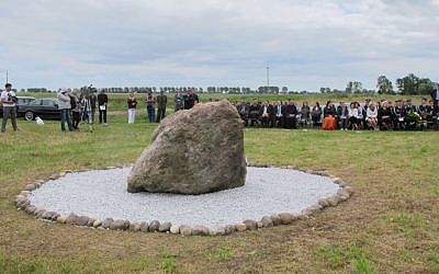 A small crowd attends the dedication ceremony of a monument at the Jewish cemetery in Rychwal, Poland. (Ruth Ellen Gruber/JTA)