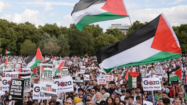 Pro-Palestinian demonstrators hold placards and wave Palestinian flags at a mass rally against Israel in London on Saturday, August 9, 2014. (photo credit: Leon Neal/AFP) Pro-Palestinian demonstrators hold placards and wave Palestinian flags at a mass rally against Israel in London on Saturday, August 9, 2014. (photo credit: Leon Neal/AFP)