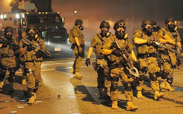 Law enforcement officers watch on during a protest on West Florissant Avenue in Ferguson, Missouri, on August 18, 2014. (photo credit: AFP/Michael B. Thomas) Law enforcement officers watch on during a protest on West Florissant Avenue in Ferguson, Missouri, on August 18, 2014. (photo credit: AFP/Michael B. Thomas)