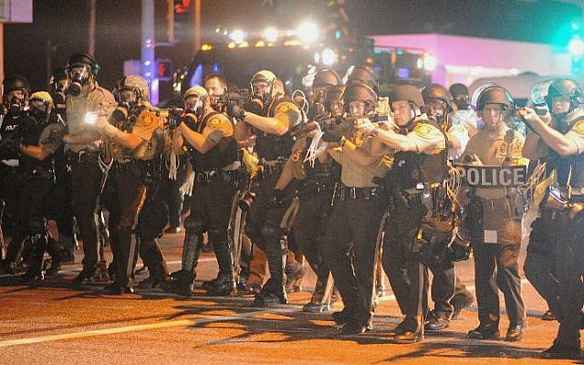Law enforcement officers watch on during a protest on West Florissant Avenue in Ferguson, Missouri on August 18, 2014. (photo credit: AFP/Michael B. Thomas)