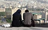 An Iranian couple sit together in the northwestern Shahran neighborhood overlooking Tehran on June 7, 2014. (AFP/Atta Kenare)