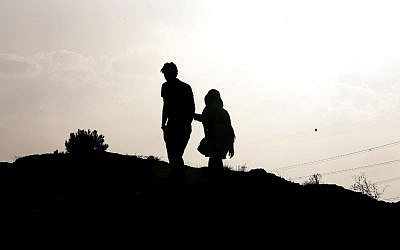 An Iranian couple walk together in the northwestern Shahran neighbourhood overlooking Tehran on June 7, 2014. (photo credit: AFP Photo/Atta Kenare) 