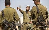 Israeli soldiers take part in a briefing at an army deployment area on the southern Israeli border with the Gaza Strip Friday, August 1, 2014. (photo credit: Jack Guez/AFP)