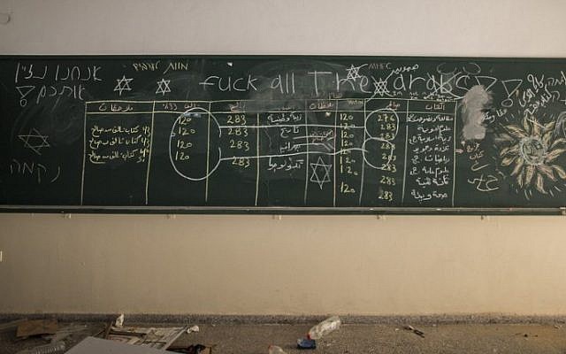 Profanities are seen written on blackboard after Israeli soldiers withdrew from the Beit Hanun High school for girls which was reportedly used as an advanced base during Israel's military offensive against the Hamas-held Gaza Strip, on August 5, 2014. (photo credit: Marco Longari/AFP)