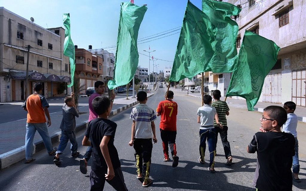 Palestinian boys carry Hamas flags as they lead a funeral procession on August 11, 2014 in Jabalia, in Gaza. (photo credit:AFP/ROBERTO SCHMIDT)