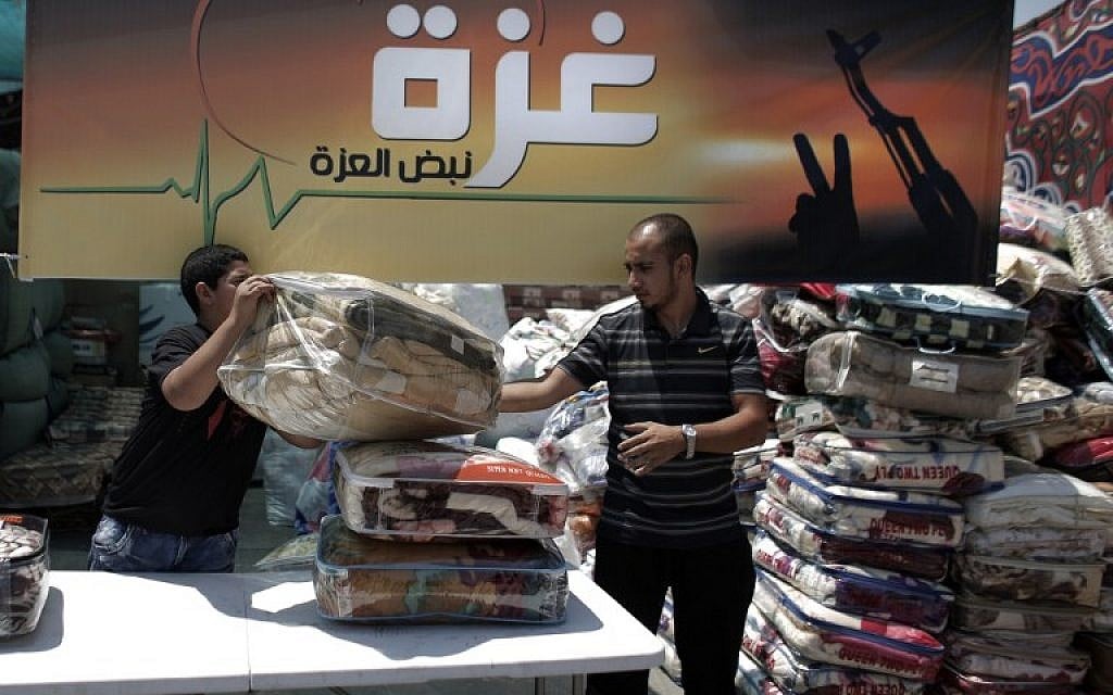 Palestinians collect goods and blankets in East Jerusalem, on Thursday, August 14, 2014, to be sent and distributed with the Red Cross to people in need in the Gaza Strip (photo credit: AFP/AHMAD GHARABLI)