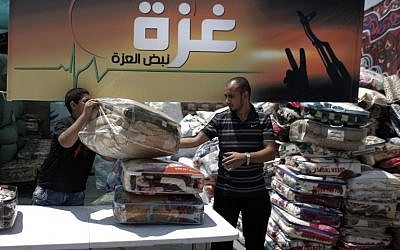 Palestinians collect goods and blankets in East Jerusalem, on Thursday, August 14, 2014, to be sent and distributed with the Red Cross to people in need in the Gaza Strip (photo credit: AFP/AHMAD GHARABLI)