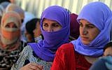 Yazidi Iraqi women queue in order to get food at the Bajid Kandala camp near the Tigris River, in Kurdistan's western Dohuk province, where they took refuge after fleeing advances by Islamic State jihadists in Iraq on August 13, 2014. Photo credit:AFP/AHMAD AL-RUBAYE)