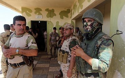 Iraqi Kurdish Peshmerga fighters monitor the area from their front line position in Bashiqa, a town 13 kilometers north-east of Mosul in Iraq, on August 16, 2014 (photo credit: AFP/AHMAD AL-RUBAYE)