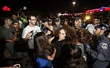 An Israeli supporter of the right-wing Lehava organization scuffles with police during a demonstration outside the wedding hall where Morel Malka, who was born Jewish, and Mahmoud Mansour, an Arab Israeli, are getting married on August 17, 2014 in Rishon Letzion. (AFP/Gali Tibbon)
