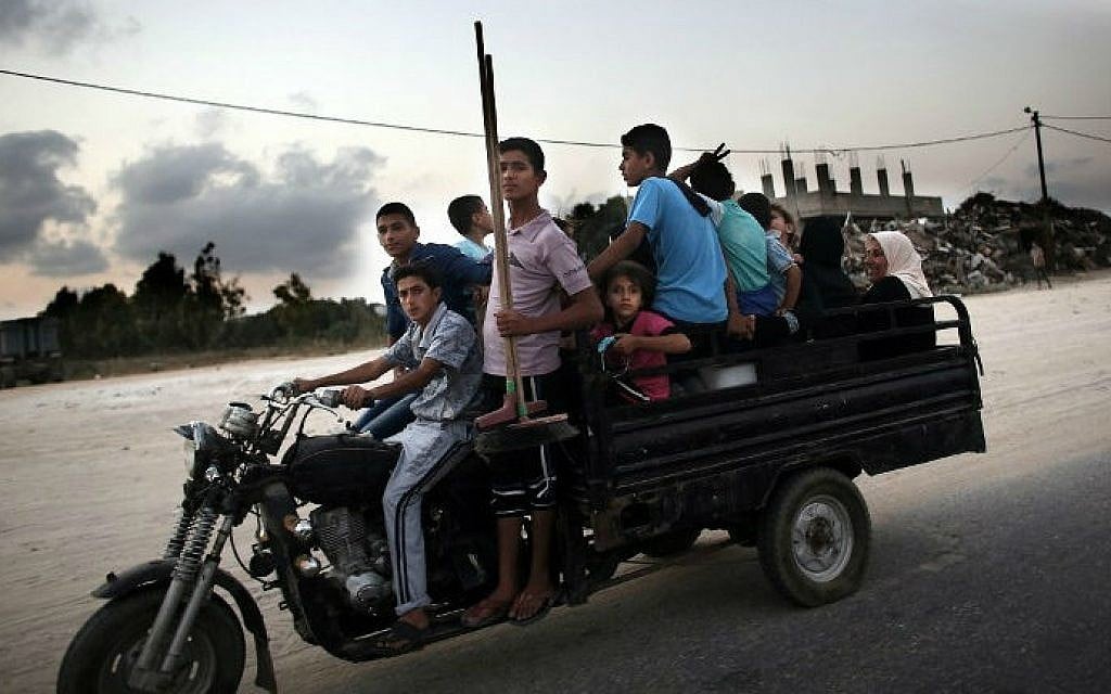 Palestinians head to a United Nations school to take refuge for the night in the northern Gaza Strip city of Beit Hanun,  just hours before the midnight expiry of a five-day ceasefire between Israel and Hamas,  August 18, 2014. The ceasefire was eventually extended for another 24-hours. (photo credit: AFP/THOMAS COEX)