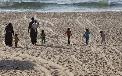 A Palestinian family walks towards the sea as they arrive to spend an afternoon on a beach in Gaza City on August 18, 2014. (photo credit:  AFP Photo/Roberto Schmidt) 