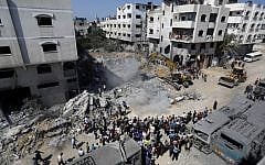 A digger removes cement and debris on August 20, 2014, of a home destroyed the night before in an Israeli airstrike on Gaza City's Sheikh Radwan neighborhood, targeting the elusive Hamas military chief Muhammad Deif (photo credit: AFP/Mohammed Abed)
