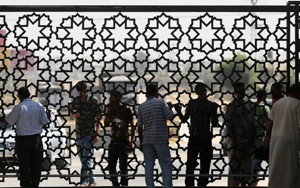 Palestinian travelers wait before crossing into Egypt at the Rafah border crossing with Egypt in the southern Gaza Strip on August 25, 2014. (photo credit: AFP Photo/Said Khatib)
