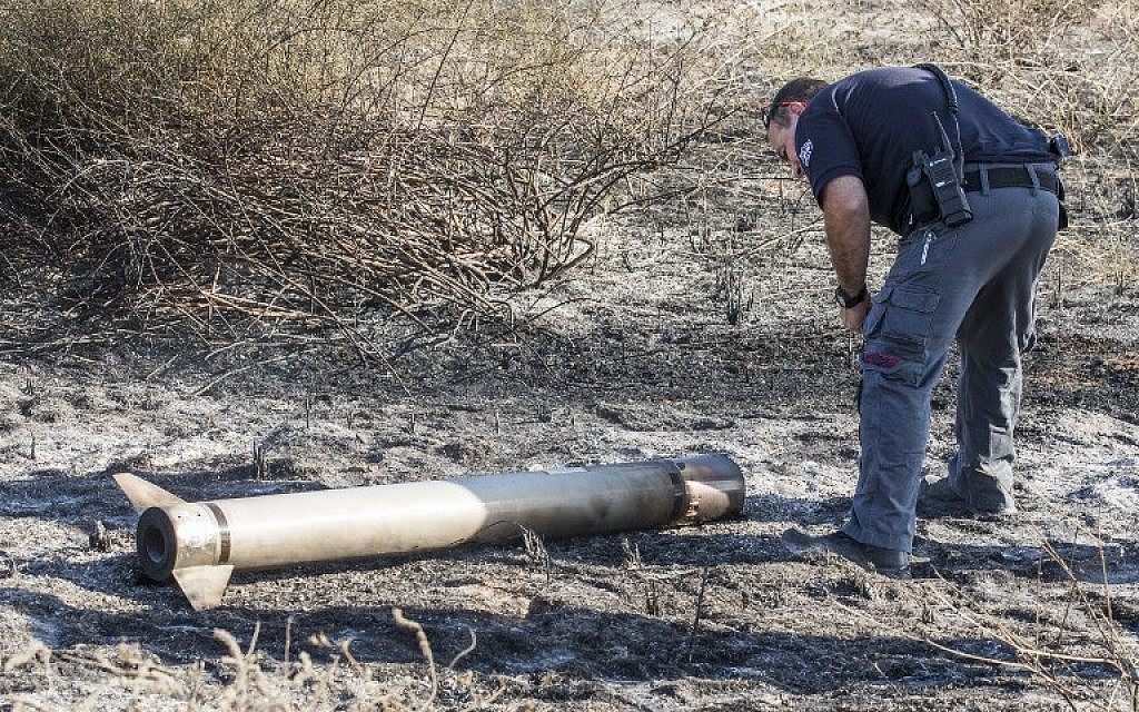 An Israeli bomb disposal expert collects the remains of a missile launched by Israel's Iron Dome defence system and that had not exploded on August 26, 2014 along the Israeli Gaza border. (photo credit: AFP/Jack Guez)