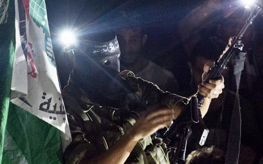 A Palestinian gunman brandishes his weapon as he fires rounds into the air after joining hundreds of Gazans gathered at an intersection in Gaza City on August 26, 2014 to celebrate a ceasefire agreement reached between Israel and Hamas (photo credit: AFP/ROBERTO SCHMIDT)