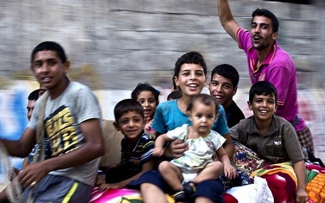 Members of a Gazan family ride on top of a horse cart as they head home with their belongings in the Shejaiya neighborhood on Wednesday, August 27, 2014. (photo credit: Roberto Schmidt/AFP)