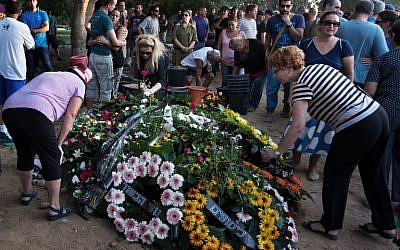Israeli mourners lay flower wreaths on the grave of Shahar Melamed, 43, who was killed the previous day by Palestinian mortar fire in Kibbutz Nirim near Israel's border with the Gaza Strip, on August 27, 2014 (photo credit: AFP/MENAHEM KAHANA) Israeli mourners lay flower wreaths on the grave of Shahar Melamed, 43, who was killed the previous day by Palestinian mortar fire in Kibbutz Nirim near Israel's border with the Gaza Strip, on August 27, 2014 (photo credit: AFP/MENAHEM KAHANA)