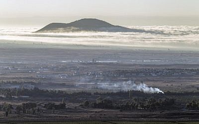 Smoke rise from the Syrian village of Quneitra, as seen from the Golan Heights, following fighting between forces loyal to Syrian President Bashar Assad and rebels over the control of the Quneitra border crossing, on August 28, 2014. (photo credit: AFP/JACK GUEZ)