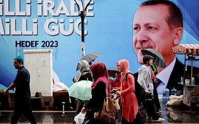 People walk past a campaign poster of Turkish Prime Minister Recep Tayyip Erdogan on Saturday, August 9, 2014, in Istanbul. (photo credit: Ozan Kose/AFP)
