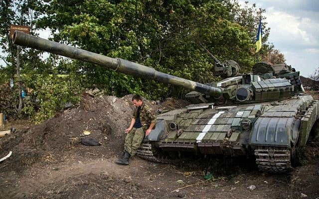 A Ukrainian serviceman sits on his tank on the frontline not far from the eastern Ukrainian city of Debaltseve, Donetsk region on August 25, 2014.  (photo credit: AFP/OLEKSANDR RATUSHNIAK) 