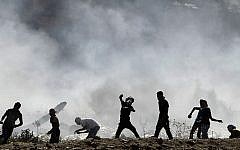 Palestinian protesters clash with Israeli security forces (unseen) following a demonstration in support of Gaza after Friday prayers at the Hawara checkpoint, east of the West Bank city of Nablus, on August 8, 2014 (Photo credit: Jaafar Ashtiyeh/AFP)