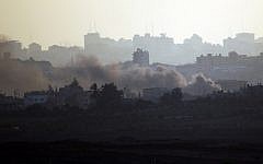A picture taken from the Israeli side of the Israel-Gaza Border on August 21, 2014, shows smoke rising from buildings in the Gaza Strip after a rocket fired from Gaza landed short of its target (photo credit: AFP/DAVID BUIMOVITCH)