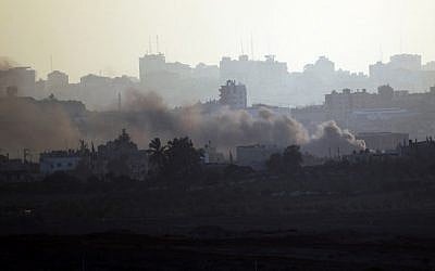A picture taken from the Israeli side of the Israel-Gaza Border on August 21, 2014, shows smoke rising from buildings in the Gaza Strip after a rocket fired from Gaza landed short of its target (photo credit: AFP/DAVID BUIMOVITCH)