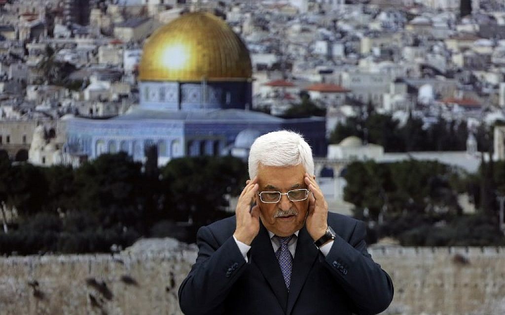 Palestinian Authority President Mahmoud Abbas recites a prayer in memory of those killed during the Gaza campaign ahead of a press conference on August 26, 2014 in the West Bank city of Ramallah, to formally announce a ceasefire with Israel.  (photo credit: AFP/Abbas Momani)