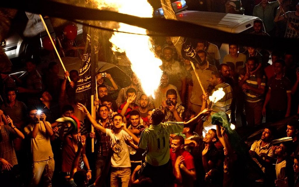 A Palestinian man blows fire as Gazans gather at an intersecition to celebrate the ceasefire between Israel and Hamas on August 26, 2014 in Gaza City. (AFP/Roberto Schmidt)