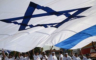 A pro-Israel group waves a huge flag during a demonstration in support of Israel during a military campaign in Gaza in the streets of Guatemala City on August 3, 2014. (photo credit: AFP Johan ORDONEZ)