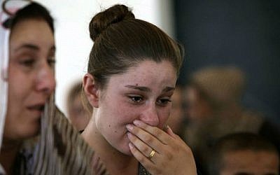 An Iraqi Yazidi woman who fled the violence in the northern Iraqi town of Sinjar, cries as she stands among others at a school where they are taking shelter in the Kurdish city of Dohuk in Iraq's autonomous Kurdistan region, on August 5, 2014. (photo credit: AFP/SAFIN HAMED) 