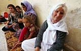 An Iraqi Yazidi family that fled the violence in the northern Iraqi town of Sinjar, sit at at a school where they are taking shelter in the Kurdish city of Dohuk in Iraq's autonomous Kurdistan region, on August 5, 2014. (photo credit: AFP/Safin Hamed)