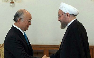 Iranian President Hassan Rouhani (right) shaking hands with Yukiya Amano (left), chief of the International Atomic Energy Agency (IAEA) during a meeting in Tehran on August 17, 2014. (photo credit: AFP/Iranian Presidency website/HO/Mohammad Berno)
