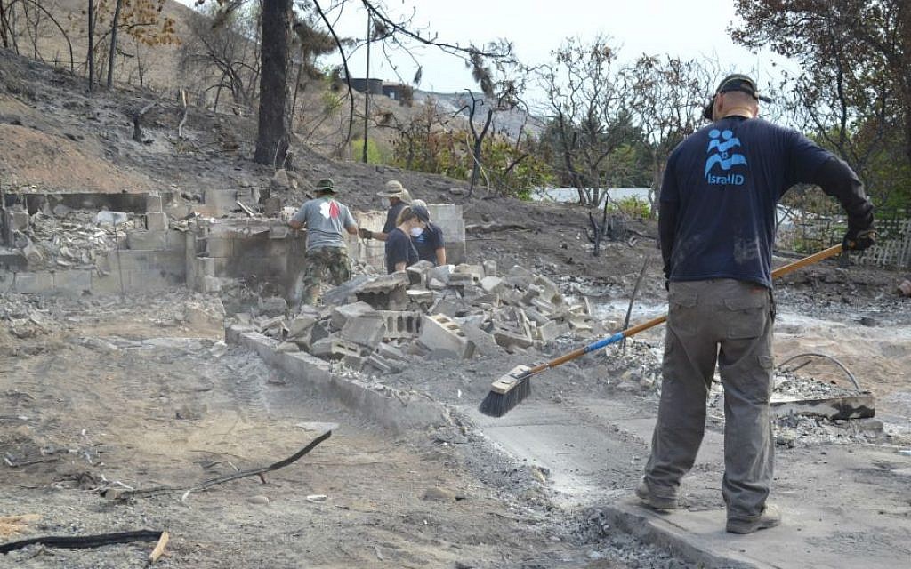 An IsraAID worker cleans rubble from the Pateros, Washington blaze that has wrought some $28 million in damage. (Emily Alhadeff/The Times of Israel) An IsraAID worker cleans rubble from the Pateros, Washington blaze that has wrought some $28 million in damage. (Emily Alhadeff/The Times of Israel)