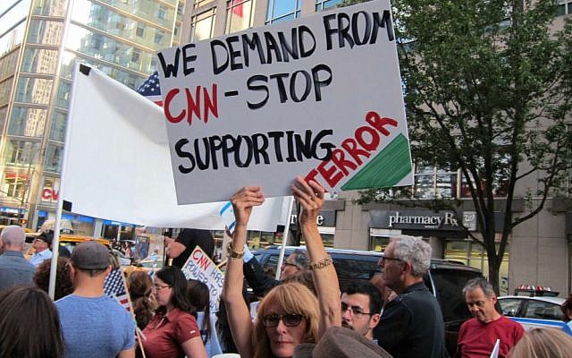 Woman at protest in front of CNN headquarters August 8, 2014 holds a sign saying, 'We demand from CNN = stop supporting terror' (Cathryn J. Prince/The Times of Israel)