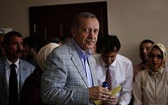 President-elect Recep Tayyip Erdogan holds his ballot paper at a polling station in Istanbul, Turkey, Sunday, Aug. 10, 2014. Turks were voting in their first direct presidential election Sunday - a watershed event in Turkey’s 91-year history, where the president was previously elected by Parliament. (Photo credit: AP/Emilio Morenatti)