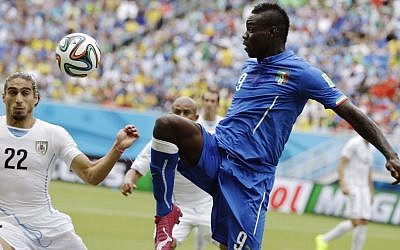Italy's Mario Balotelli  kicks the ball over Uruguay's Martin Caceres at the 2014 World Cup, June 24, 2014 (AP/Ricardo Mazalan)