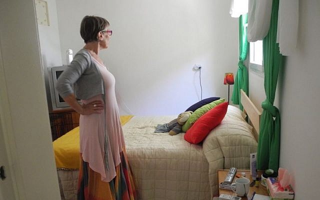 Adele Raemer, an English teacher and resident of Kibbutz Nirim, which is located two kilometers from Gaza, in the safe room she converted to her bedroom.  Raemer is unsure if the school year will start since there are almost no children remaining at the kibbutz during the barrage of rockets. (photo credit: Melanie Lidman/Times of Israel)