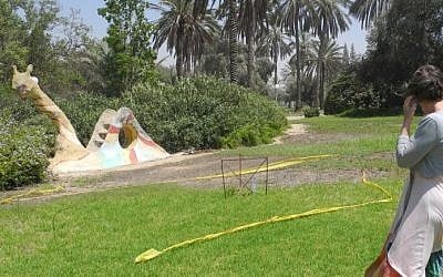 Adele Raemer points out an unexploded missile just 20 meters from the kibbutz playground on Tuesday, August 6, at Kibbutz Nirim near Gaza. (photo credit: Melanie Lidman/Times of Israel)