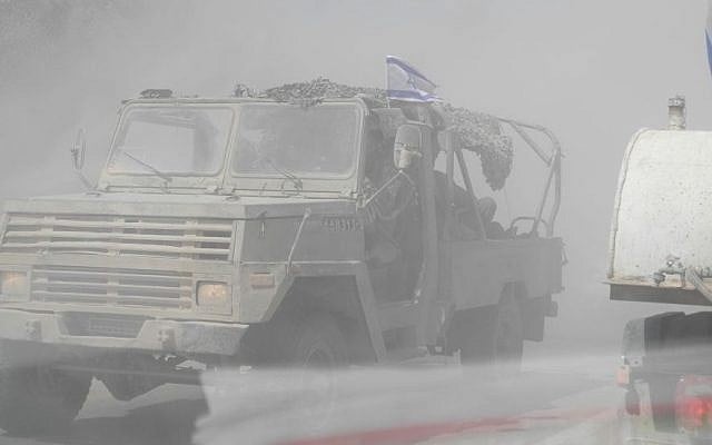Soldiers in this open sided military vehicle inhaled a lot of dust on Tuesday with so many army vehicles on the move. (photo credit: Melanie Lidman/Times of Israel)