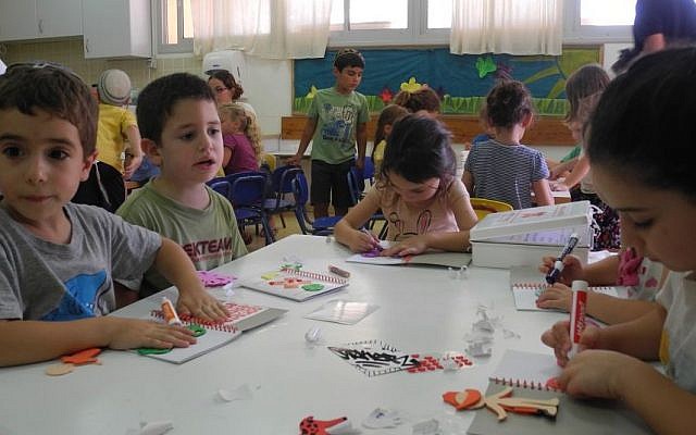Kids at Kibbutz Alumim decorate journals for their emergency art therapy kits on Wednesday. (Melanie Lidman/Times of Israel) Kids at Kibbutz Alumim decorate journals for their emergency art therapy kits on Wednesday. (Melanie Lidman/Times of Israel)