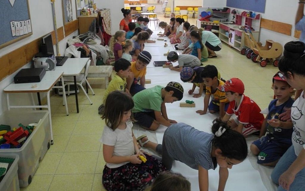 Children from Kibbutz Alumim in southern Israel make a mural of animals that make them feel strong, with Artists 4 Israel on Wednesday, August 13, 2014. (Melanie Lidman/Times of Israel)