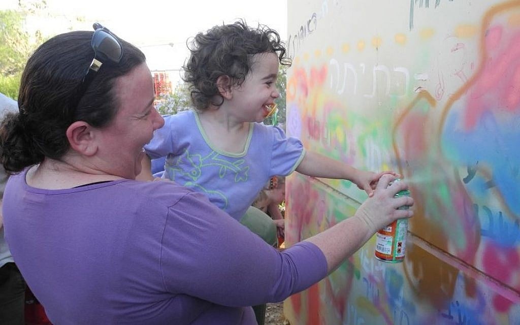 Kibbutz Alumim residents paint a bomb shelter with with members of the art advocacy group Artists 4 Israel on Wednesday. (Melanie Lidman/Times of Israel) Kibbutz Alumim residents paint a bomb shelter with with members of the art advocacy group Artists 4 Israel on Wednesday. (Melanie Lidman/Times of Israel)