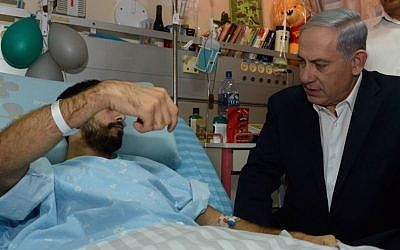 Prime Minister Benjamin Netanyahu visits Israeli soldiers who were injured during Israel's Operation Protective Edge, at the Soroka Medical center in Beersheba on August 04, 2014. (Photo credit: Haim Zach / GPO/FLASH90)
