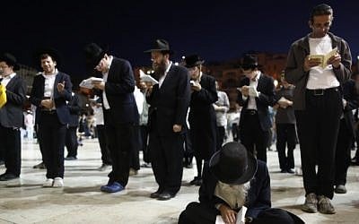 Orthodox Jewish men pray as they gather for the ritual of Tisha B'Av at the Western Wall in the Old City of Jerusalem, August 04, 2014.  (Photo credit: Yonatan Sindel/Flash90)