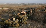 Israeli soldiers rest in southern Israel along the border with Gaza (background), August 06, 2014. (Photo credit: Miriam Alster/Flash90)