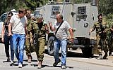 Israeli soldiers at the scene where a rocket had exploded and fallen near the border with the Gaza Strip on August 8, 2014. (Photo credit: Edi Israel/Flash90)