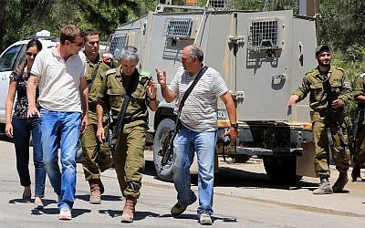 Israeli soldiers at the scene where a rocket had exploded and fallen near the border with the Gaza Strip on August 8, 2014. (Photo credit: Edi Israel/Flash90)