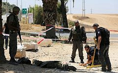 Police sappers inspect a part of a rocket that had exploded and fallen near the border with the Gaza Strip on August 8, 2014.(photo credit: Edi Israel/Flash90)